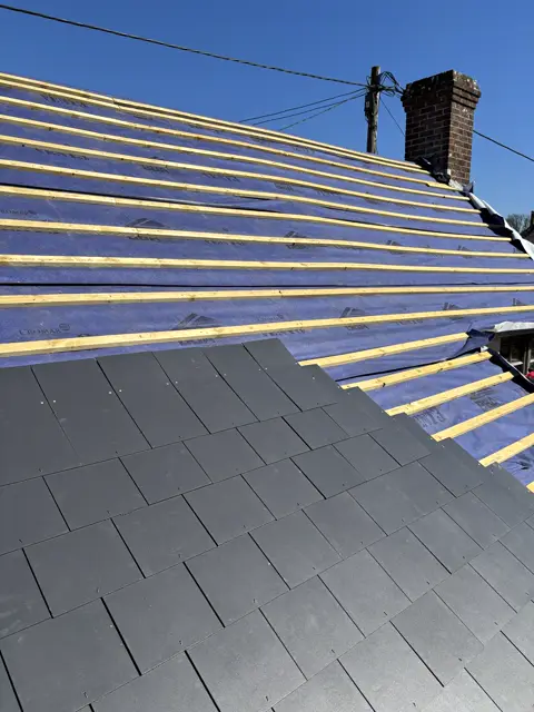 Perfect batten lines, slates going on: slate roof by LR Roofing near Weymouth, Dorset