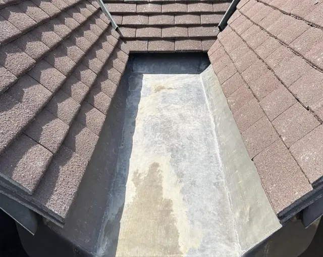 Lined valley between tiled slopes: leadwork and chimney by LR Roofing near Weymouth, Dorset