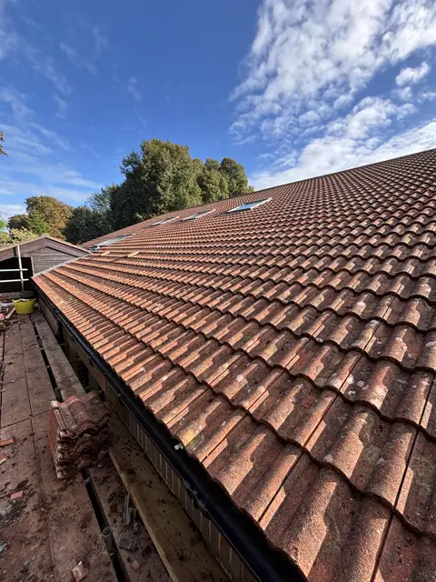 Relaid pantiles, crisp lines, blue sky: tile roof by LR Roofing near Weymouth, Dorset