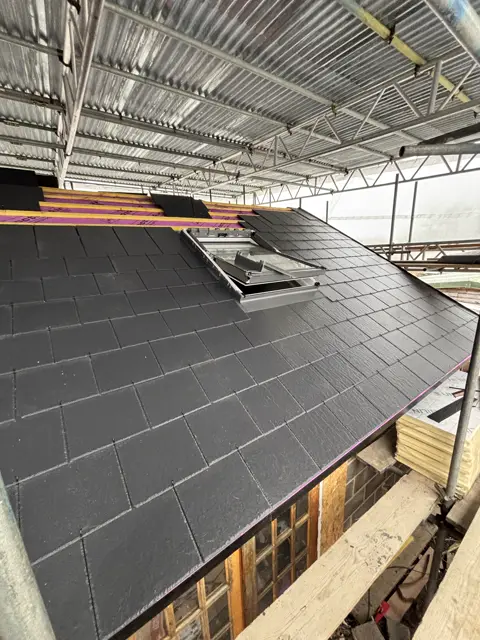 Neat slate courses with new rooflight: slate roof by LR Roofing near Weymouth, Dorset