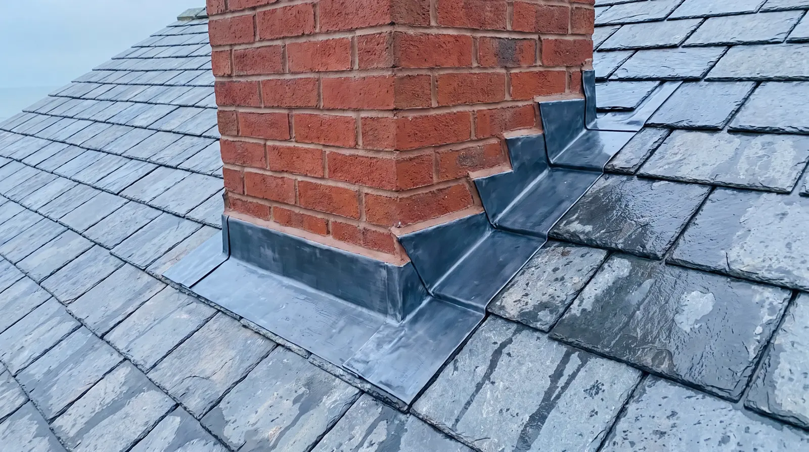 New stepped lead flashing around a brick chimney