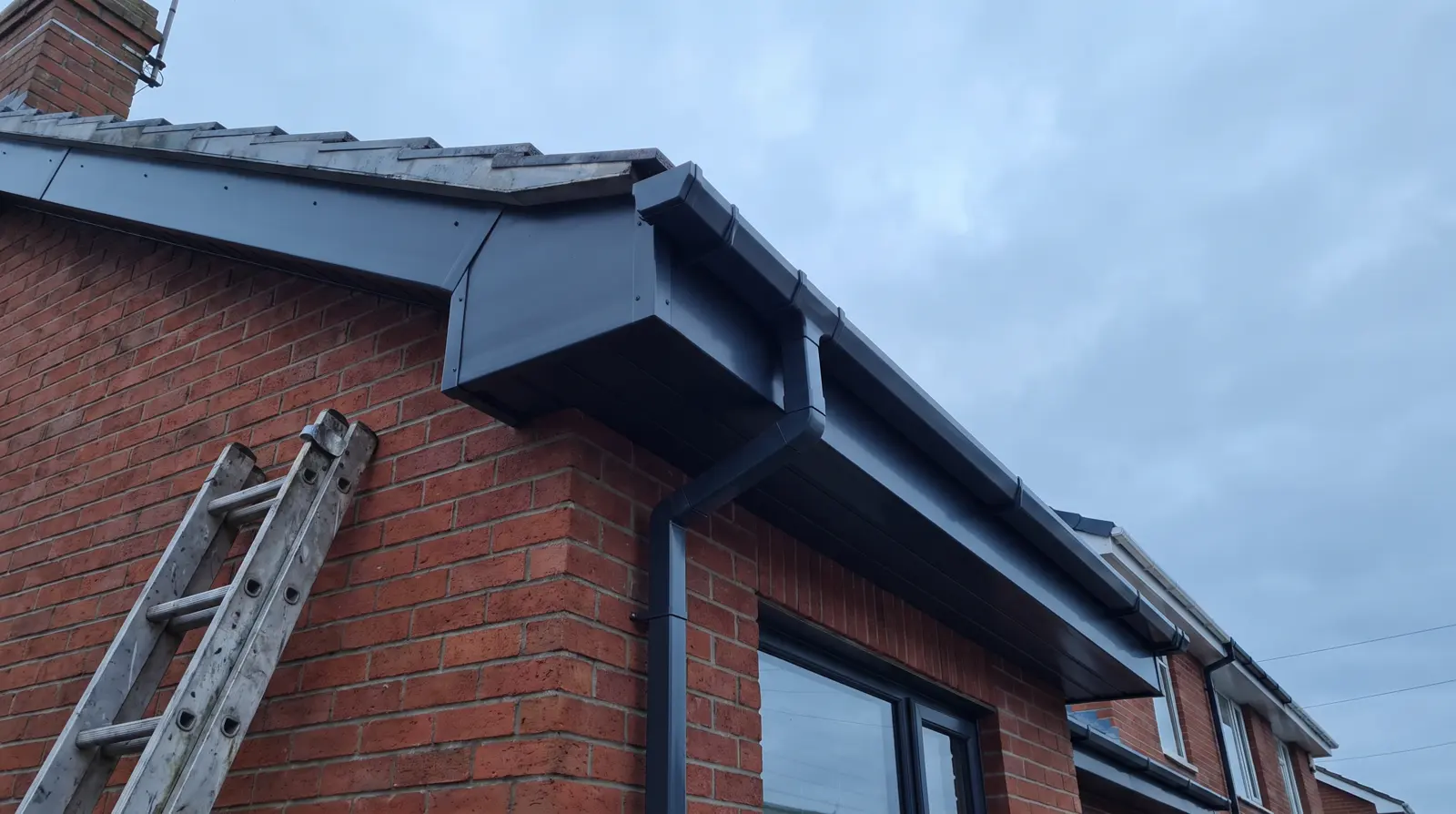 New anthracite fascias, soffits and guttering on a brick house